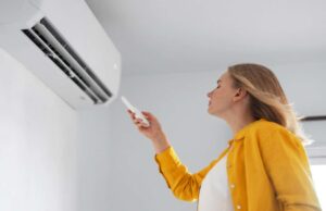 Sıcakları Yenmenin En Kolay Çözümü: İşte Türkiye’deki En Uygun Klima Modelleri klimayı açan ve serinleyen kadın